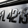 Metallic badge with 'FL4213' on a reflective surface