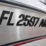Metallic surface with 'FL 2597 AR' text and a red and blue stripe.