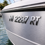 Boat hull with registration number 'HI 2287 RT' on a body of water.