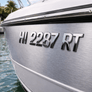 Boat hull with registration number 'HI 2287 RT' on a body of water.